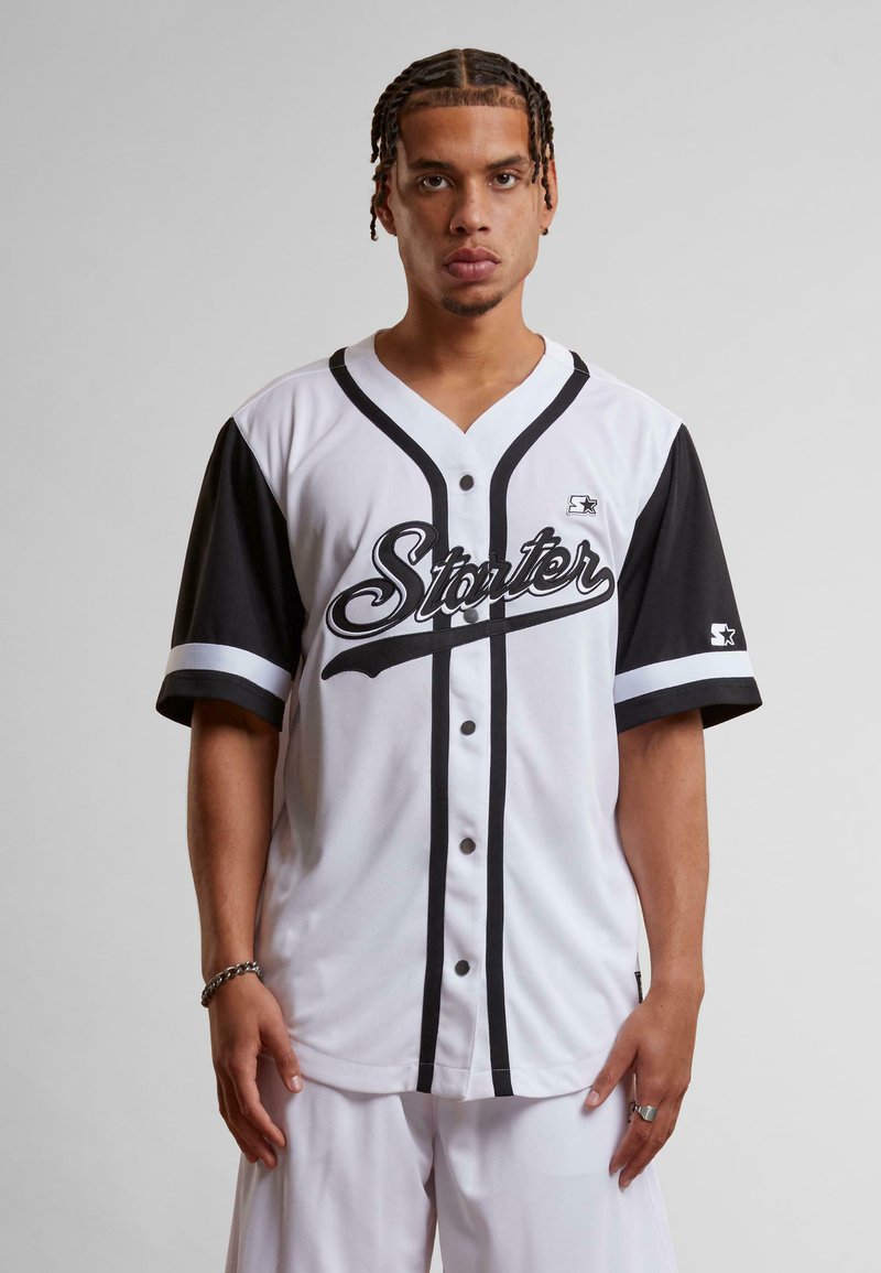 Bela kratka majica za baseball s črnimi detajli, z gumbi spredaj, logotip "Starter", kontrastne črte na rokavih in gladka tkanina.