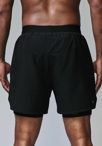 Czarne sportowe szorts z miękką teksturą, elastycznym pasem, tylną kieszenią i podszewką. Profesjonalny, lekki design do aktywności fizycznej.