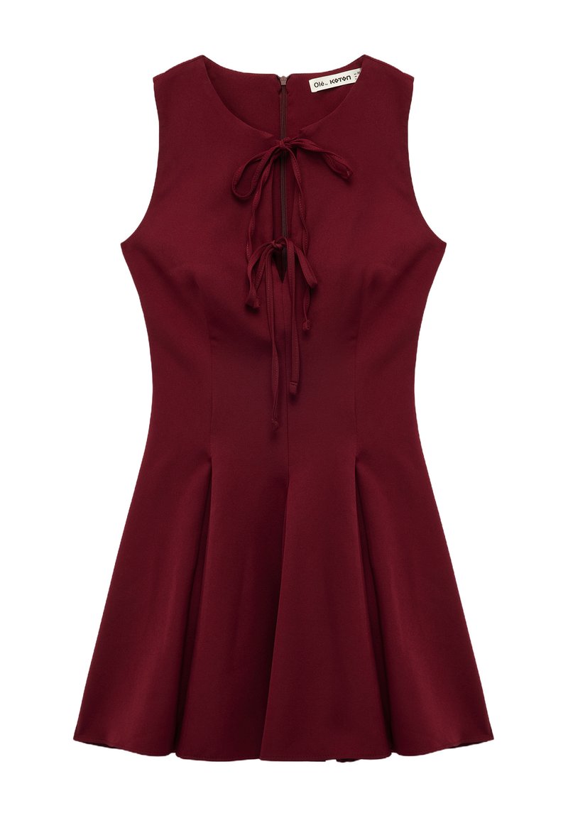Abito senza maniche color bordeaux con corpino aderente, gonna svasata e chiusura con lacci regolabili al collo. Tessuto liscio senza motivi discernibili.