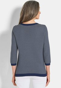 Gestreifter Pullover in Navy und Weiß mit rundem Ausschnitt und dreiviertellangen Ärmeln. Rippbündchen und Saum sorgen für eine strukturierte Optik.