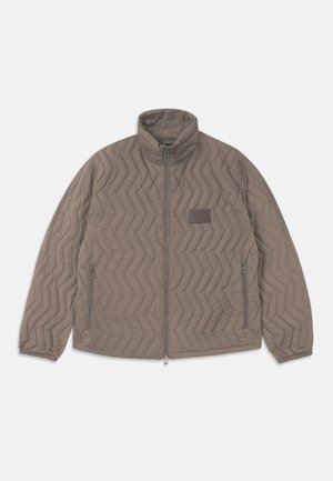 Quiltet brun jakke med høj krave, lynlås foran og to sidelommer. Har et diagonalt zigzag-mønster og en lille stoflabel.