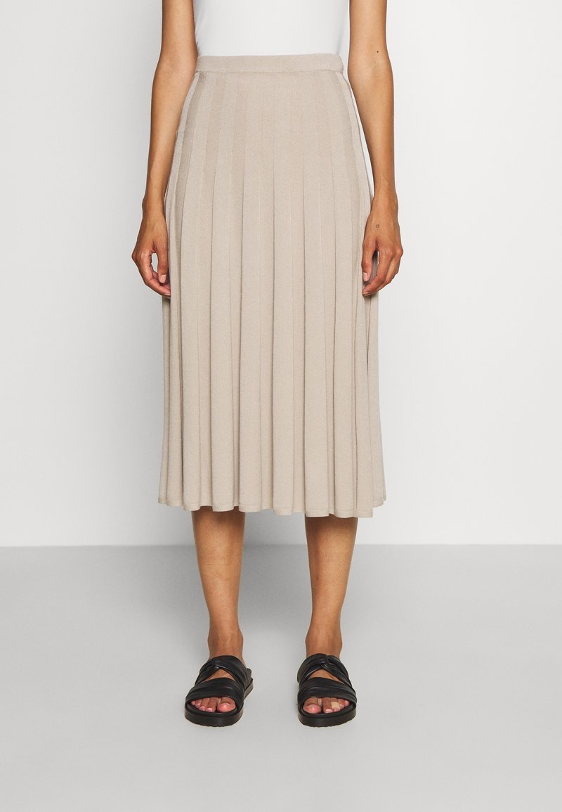 Beige, plissierter Midirock aus einem weichen, strukturierten Stoff. Verfügt über einen taillierten Bund und reicht bis unter das Knie. Kombiniert mit schwarzen Sandalen.