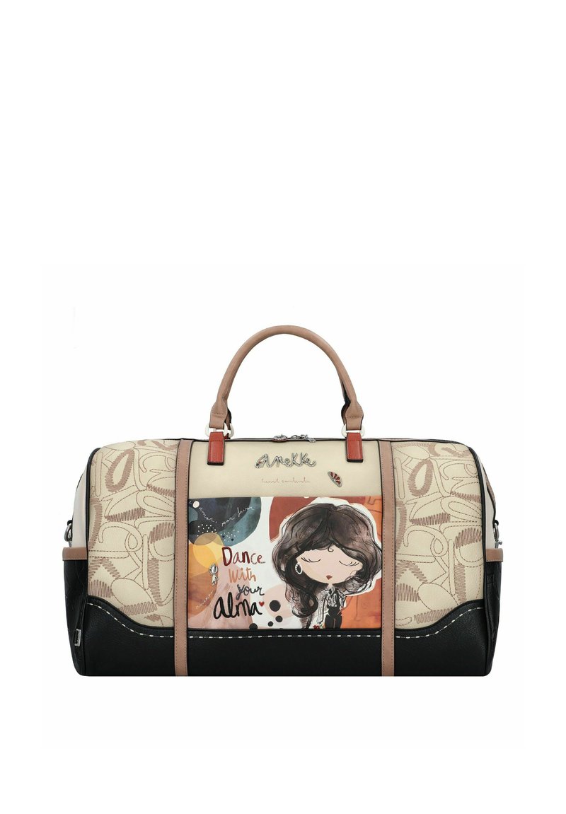 Sac de voyage beige et noir avec illustration et texte, doté d'une finition synthétique lisse, de doubles poignées et d'accents en cuir contrastants.