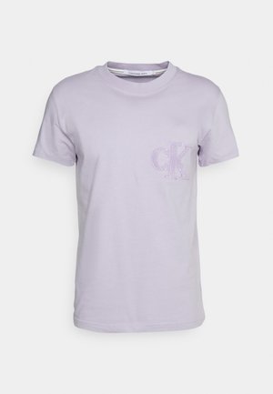 Jasnofioletowy bawełniany t-shirt z krótkim rękawem, okrągłym dekoltem i małym wyszywanym logo "cK" na lewym ramieniu.