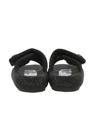 Paire de sandales noires à enfiler avec des brides velcro réglables et des semelles texturées, vues de dos.