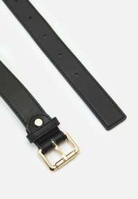 Cinto de couro preto com superfície texturizada, apresentando uma fivela de metal dourado, buracos ajustáveis e um detalhe de fecho com botão de pressão.