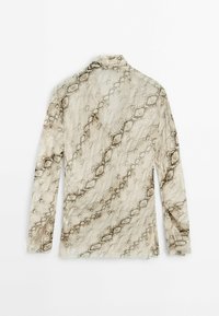 Haut beige à manches longues avec motif serpent marron et noir, col montant, tissu léger et semi-transparent posé à plat.