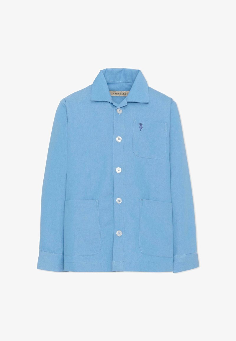 Chemise bleu clair à manches longues avec col et trois poches avant, arborant un petit logo brodé bleu foncé sur la poche poitrine.