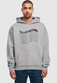 Hoodie en coton gris avec un grand graphique "GOOD KARMA" en noir et gris, poche kangourou et poignets côtelés. Design à coupe décontractée.