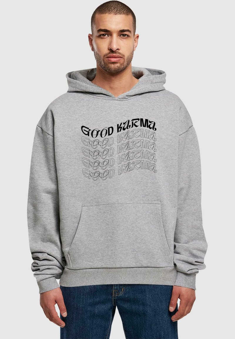 Hoodie en coton gris avec un grand graphique "GOOD KARMA" en noir et gris, poche kangourou et poignets côtelés. Design à coupe décontractée.