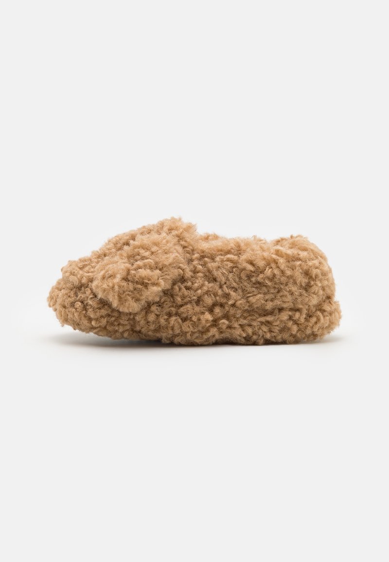 Chausson en polaire bouclée marron doux avec un bout arrondi et une texture moelleuse et confortable.