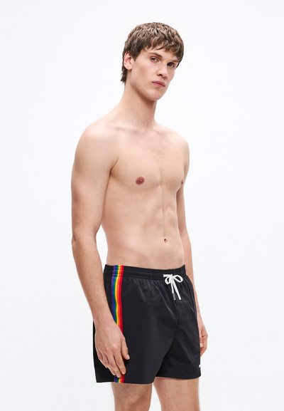 Șort de baie negru cu detalii laterale în dungi curcubeu, talie cu șnur și material ușor. Designul prezintă o croială lejeră.