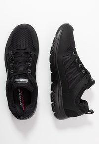 Černé sportovní boty vyrobené z textilie a syntetických materiálů. Mají zaoblenou špičku, strukturovaný povrch, flexibilní podrážku a šněrování.