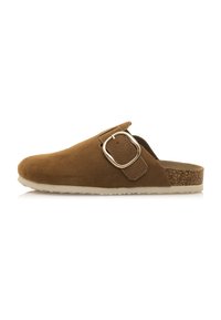 Mocassin en cuir suède brun à enfiler avec un bout arrondi et un détail de boucle sur le côté. Dispose d'une semelle intermédiaire texturée en liège et d'une semelle extérieure en caoutchouc pour une bonne traction.