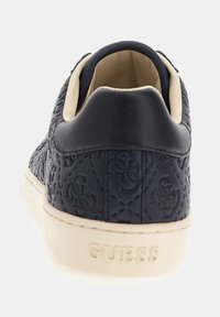 Sneaker blu scuro in pelle textured, con motivo del logo dorato, suola color crema e colletto imbottito per il comfort. Presenta un branding sottile sul tallone.