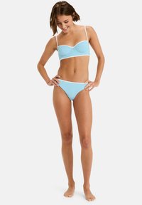 Light blue bikini set featuring a padded bralette top with white trim and matching low-rise bottoms, made from smooth, stretchy material.