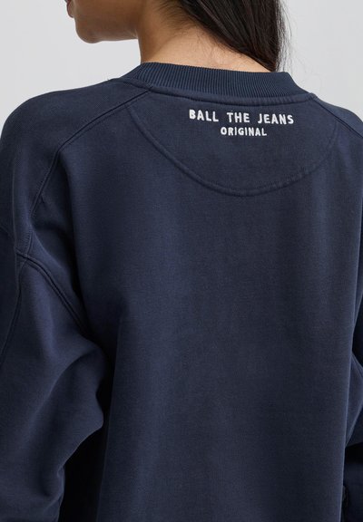 Námornícka modrá mikina so žebrovaným výstrihom. Na zadnej strane je text "BALL THE JEANS ORIGINAL" bielou vyšívkou. Štruktúrovaná látka.