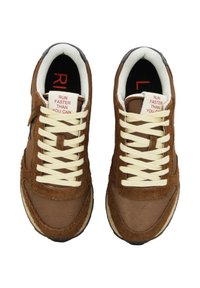 Brązowe sneakersy wykonane z połączenia zamszu i siateczki, z kremowymi sznurowadłami i etykietą wewnątrz, na której widnieje napis "BIEGAJ SZYBCIEJ, NIŻ POTRAFISZ".