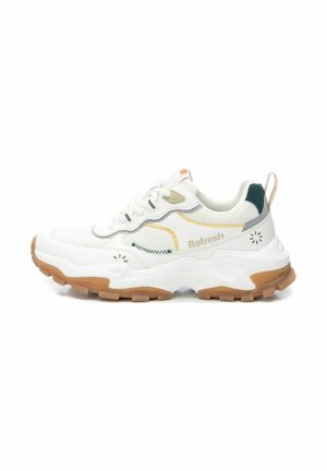 Zapatilla deportiva blanca con acentos en gris, amarillo y verde, parte superior de malla, suela de goma gruesa y un cuello acolchado para mayor comodidad.