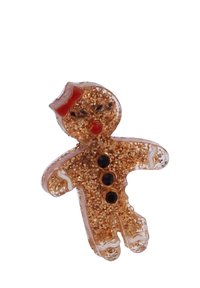 Adorno de hombre de jengibre hecho de un material transparente relleno de purpurina dorada. Presenta acentos rojos, cuentas negras como botones y una cara sonriente.