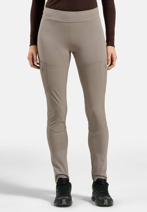 Beige Outdoor-Hosen mit mittelhohem Bund, seitlichen Reißverschlusstaschen und verstärkten Kniepartien. Das Material ist leicht und dehnbar.