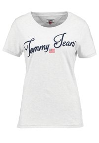 Světle šedé tričko z bavlny s krátkými rukávy a kulatým výstřihem. Má námořnický text "Tommy Jeans" a malý detail americké vlajky.