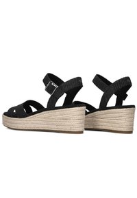 Zwarte wedge sandalen met een crisscross bandontwerp, geweven jute hak en verstelbare gesp sluiting. Textuurstof bovenkant met een gladde voering.
