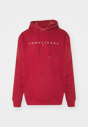 Rode pullover hoodie met voorzak, trekkoorden en "TOMMY JEANS" tekst met logo gecentreerd op de borst.
