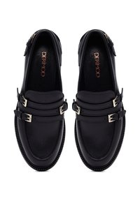 Zwarte leren loafers met dubbele gesps, ronde neus, gestikte detailing en een gestructureerde zool. Fabrikantenlogo zichtbaar aan de binnenkant.