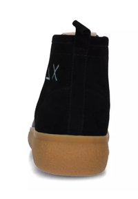 Stivale alla caviglia in suede nero con suola in gomma, dotato di un pratico passante sul retro e dettagli di cucitura discreti. Design minimalista senza motivi.