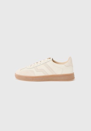 Beige sneakers med tekstureret gummisål, rund tå, glat stofoverdel og kontrasterende sidelommer. Snørelukning.