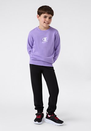 Paarse sweatshirt met lange mouwen en een wit logo, zwarte joggingbroek en zwarte sneakers met rode accenten. Soepele textuur, casual ontwerp.