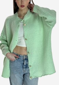 Cárdigan de punto color verde menta con escote redondo, botones al frente y ajuste holgado. Presenta puños acanalados y un patrón texturizado.