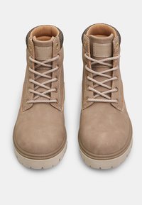 Botine din suede bej, cu vârf rotund, cu șireturile tot bej și accente tricotate texturate în partea de sus, având o talpă din cauciuc cu un model de profunditate.