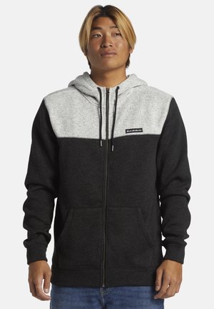 Gray and black zip-up hoodie made of soft fabric, featuring a hood, front pockets, and a logo patch on the chest area.