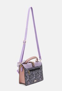 Skrupulatna torebka o strukturze z czarno-szarym wzorem węża, lawendowymi akcentami i krótkim uchwytem; zawiera fioletowy regulowany pasek na ramię.