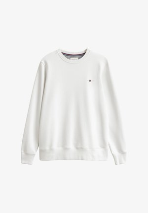 Sweat-shirt blanc à manches longues avec col rond, poignets et ourlet côtelés, avec un petit logo bouclier rouge, blanc et bleu sur la poitrine gauche.