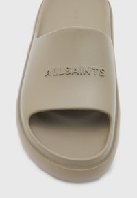 Sandale slidante bej, realizată dintr-un material neted, cu vârful deschis foarte lat și logo-ul „ALLSAINTS” embosat; talpă texturată pentru aderență.