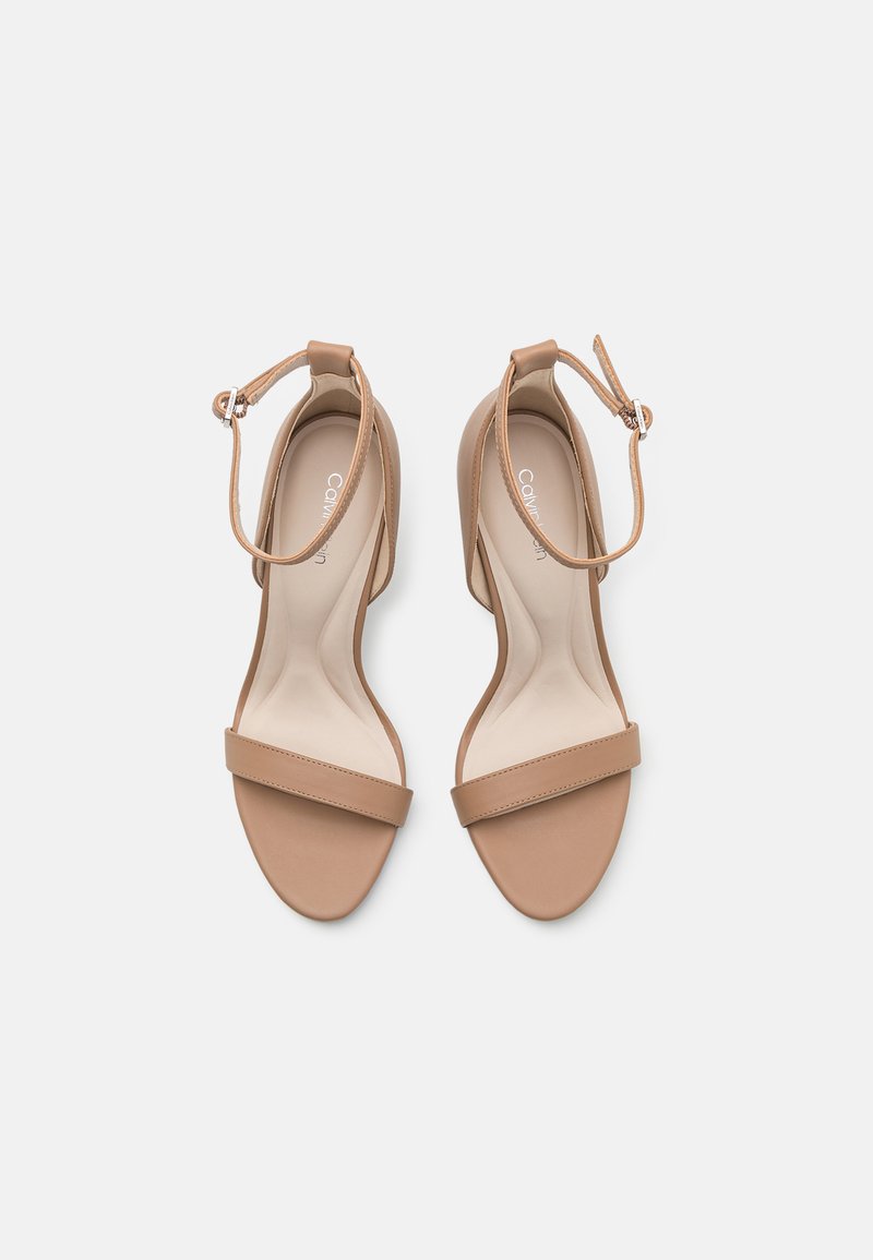 Sandales en cuir tan avec une large bride avant et une bride de cheville réglable. Texture lisse et design ouvert pour le confort et la respirabilité.