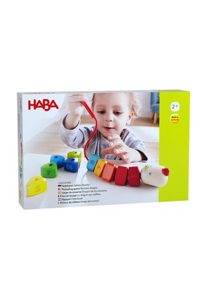 Young child threading colorful wooden number blocks shaped like a dragon on a red string, learning numbers and coordination.