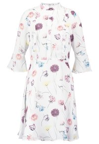 Blommig klänning i lätt material med vit bakgrund, lila, rosa och gula blommor, volangkrage och svängda ärmar.