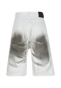 Shorts en denim blanc avec des taches dégradées noires autour des poches arrière et de la partie basse du dos, dotés d'un patch ceinture noir.