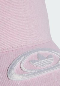 Pink cotton cap with a textured finish; features a large white embroidered logo with leaf accents on the front.