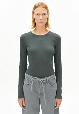 Long-sleeve, dark green ribbed shirt with a round neckline, paired with light gray pants featuring drawstring and front pockets.