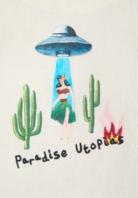 OVNI aspirant une danseuse de hula entre deux cactus avec des flammes à proximité et le texte « Paradis Utopies » brodé en dessous.