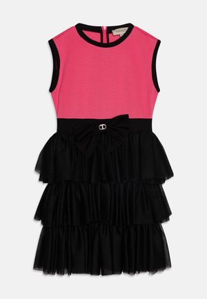 Robe sans manches avec un haut rose et une jupe à volants en noir en niveaux, présentant un accent en nœud à la taille avec un détail métallique.