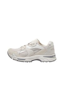 Beżowe buty do biegania z połączeniem zamszu i materiału meshowego, zaokrąglony nosek, wyściełany kołnierz oraz szara gumowa podeszwa z akcentami.