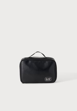 Czarny prostokątny kosmetyczka o teksturowanej powierzchni, z górnym uchwytem, zamkiem błyskawicznym i białym logo EA7 Emporio Armani z przodu, w dolnym prawym rogu.