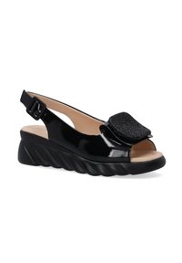 Zwarte gepatineerde slingback schoen met een gestructureerde zwarte accent, open teen en een wigzool met een golvend ontwerp. Gespsluiting voor een veilige pasvorm.