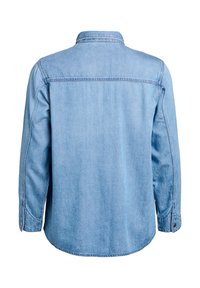 Svetlomodrá rifľová bunda s dlhými rukávmi, zapínaním na gombíky na manžetách a sedlom cez hornú časť chrbta.